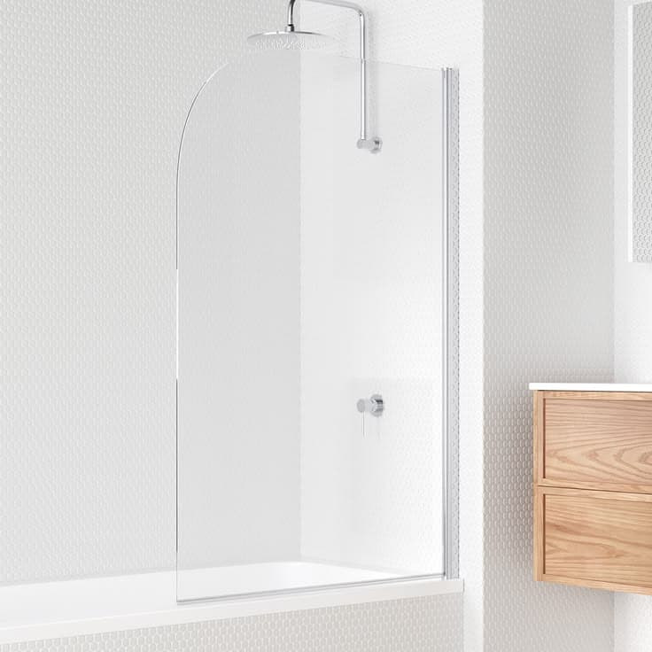 Semi-frameless bath screen with a chrome aluminium side channel and curved top edge, mounted on a white bathtub in a minimalist white tiled bathroom with timber vanity.