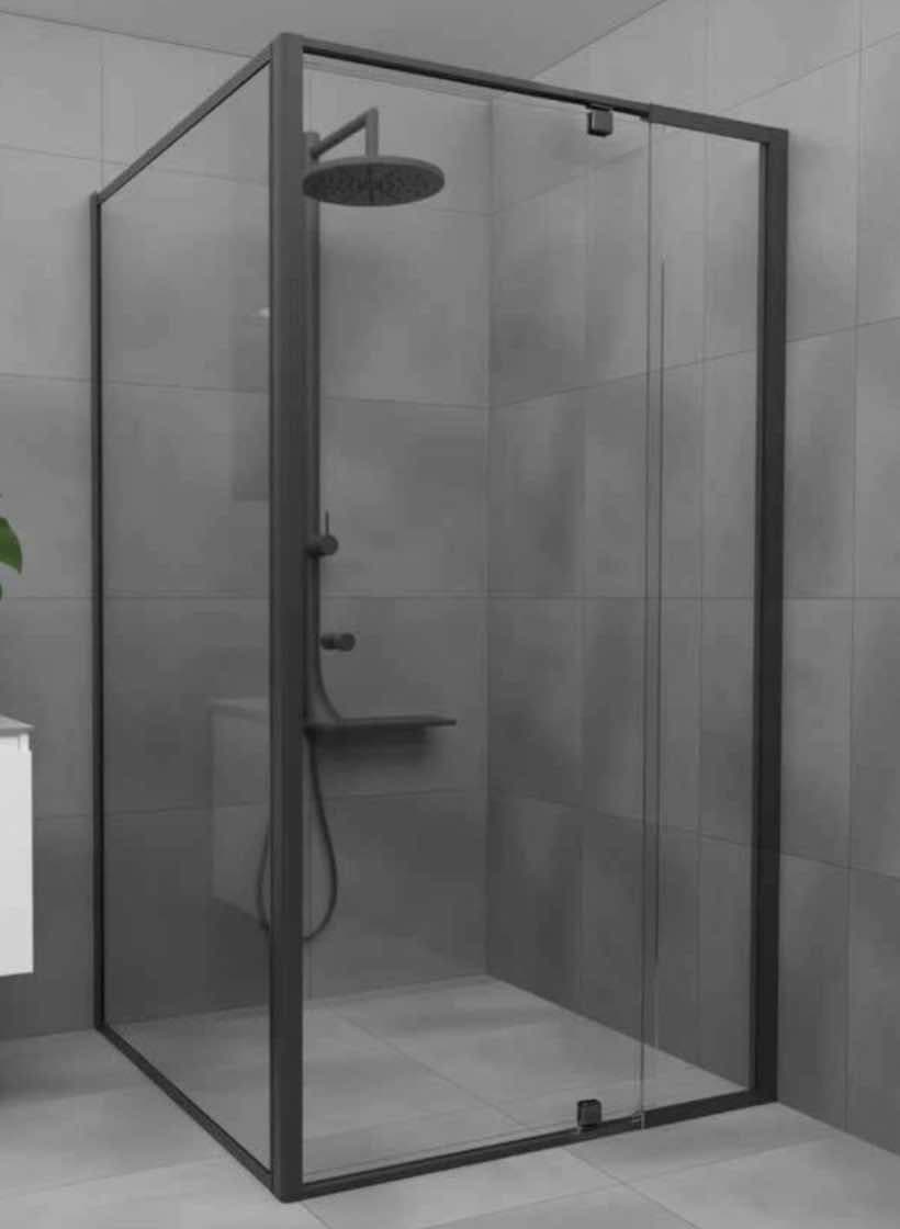 Semi-frameless shower enclosure with full matte black aluminium frame rails on all edges and a sliding door configuration in a grey tiled bathroom.