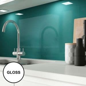 Teal gloss glass splashback mounted behind a kitchen sink with a brushed nickel mixer tap and white cabinetry.